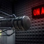 Radio microphone in studio with "On Air" sign.