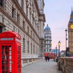 Red telephone booth near Big Ben in London.