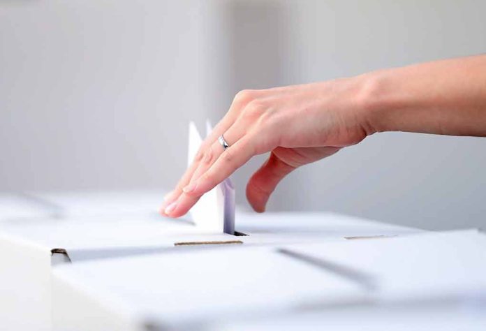 644008300 featured image Hand placing paper in ballot box.