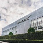 SpaceX building with logo and rocket in front.
