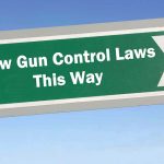 Sign: "New Gun Control Laws This Way" with arrow.