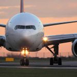 Airplane on runway at sunset, front view.