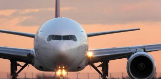 Airplane on runway at sunset, front view.