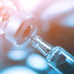 Syringe needle inserted into a vial stopper.