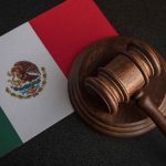 Gavel on Mexican flag background.