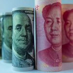 Rolled banknotes of US dollars and Chinese yuan