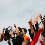 People protesting with signs and a megaphone outdoors