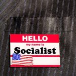 "Hello my name is Socialist" name tag on suit.