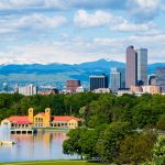 City skyline with a lake and distant mountains