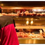 man arranges fast food items in a restaurant
