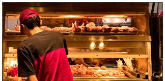 man arranges fast food items in a restaurant