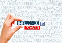 Fingers pinching text that says influence is power.