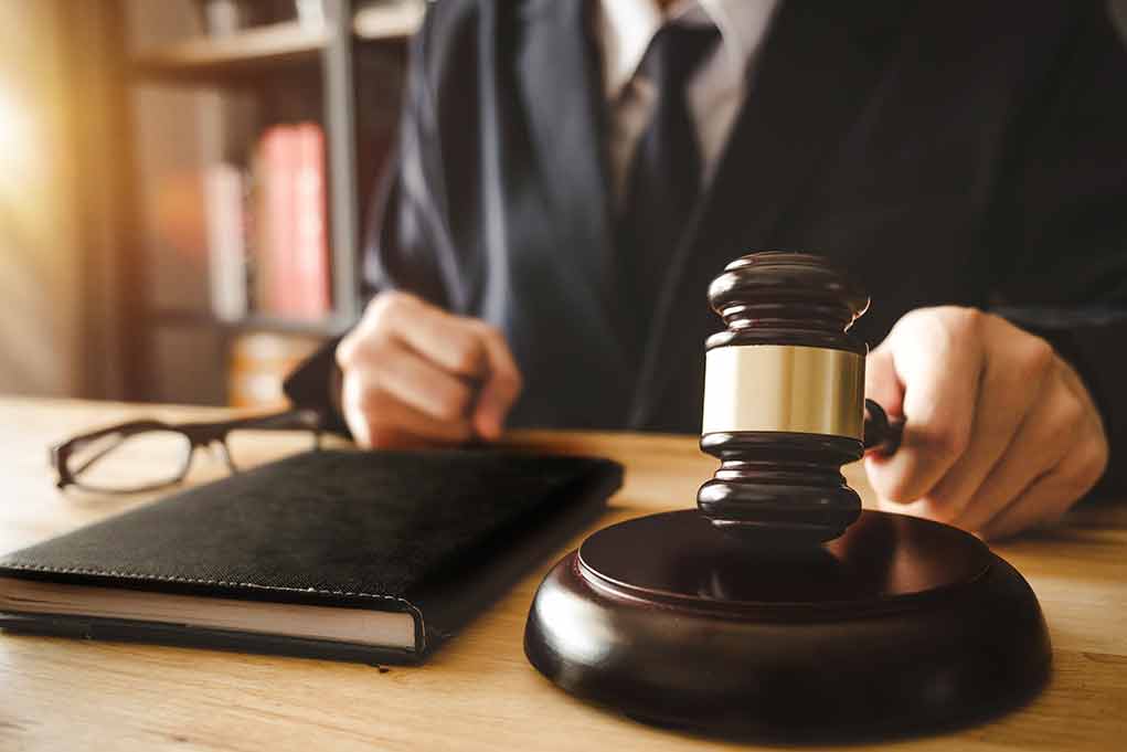 Gavel on table with glasses and notebook