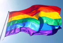 Rainbow flag waving against a clear sky