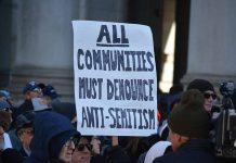 People holding sign against antiSemitism at protest