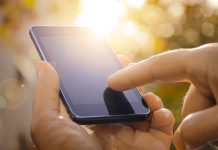 Close-up of a hand using a touchscreen smartphone.