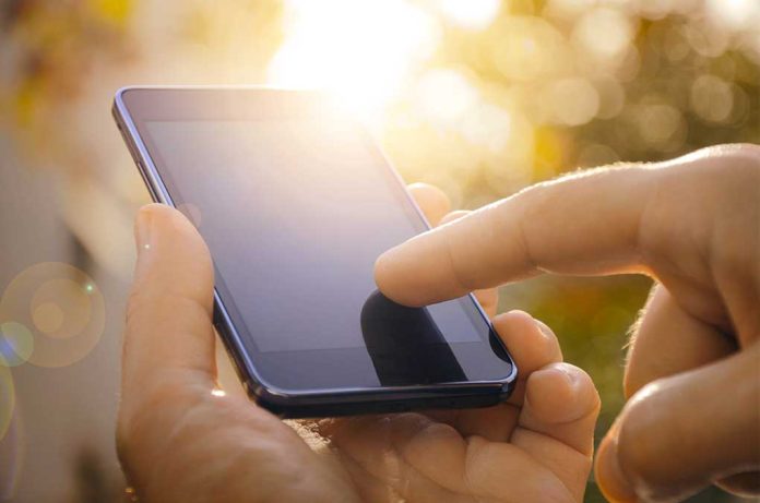 Close-up of a hand using a touchscreen smartphone.