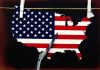 Scissors cutting USA map with flag pattern.