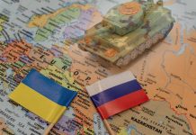 Toy tank on map with Ukraine and Russia flags