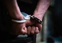 Hands in handcuffs behind back close up