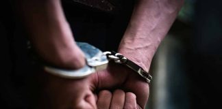Hands in handcuffs behind back close up