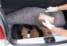 Person removing packages from car trunk.