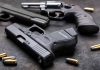 Pistols with scattered bullets on a dark surface