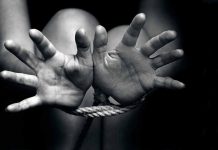 Open hands tied with rope in black and white