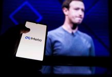 Hand holding phone displaying Meta logo screen