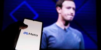 Hand holding phone displaying Meta logo screen