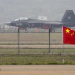 Jet with marking behind barbed wire fence