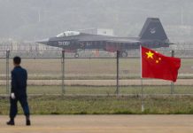 Jet with marking behind barbed wire fence