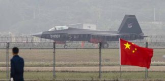 Jet with marking behind barbed wire fence