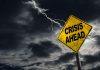 Crisis Ahead sign against stormy sky with lightning