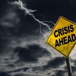 Crisis Ahead sign against stormy sky with lightning