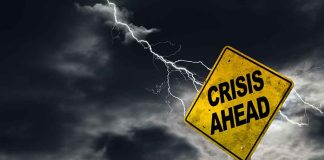 Crisis Ahead sign against stormy sky with lightning