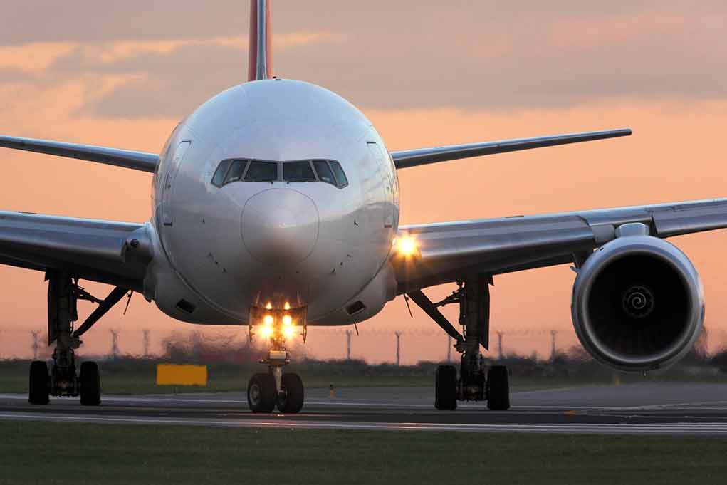 Airplane on runway during sunset with lights on