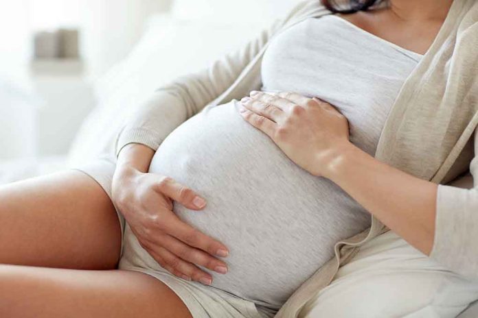 564114571 featured image Pregnant woman holding her belly, sitting comfortably.