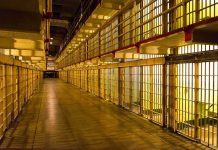Empty hallway between rows of prison cells