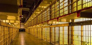 Empty hallway between rows of prison cells