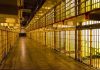 Empty hallway between rows of prison cells