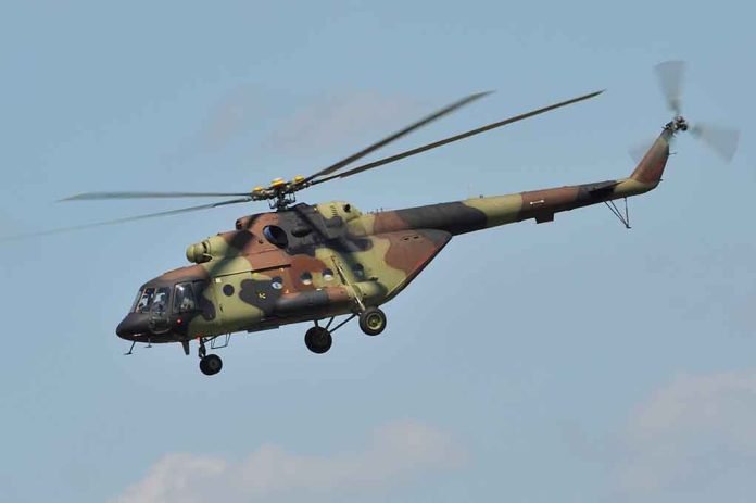 1406447873 featured image Camouflage military helicopter in flight against blue sky.
