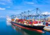 Container ship docked at a busy industrial port