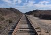 Railway tracks stretching into the distance surrounded by vegetation
