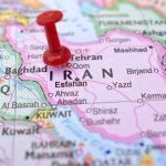Red pushpin marking Iran on a map