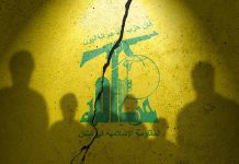 Yellow wall with cracked logo and shadowy figures
