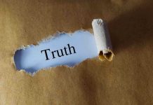 Ripped paper reveals word truth underneath brown surface