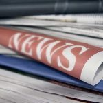 Stack of newspapers with NEWS headline visible