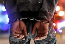 Person in handcuffs with colorful lights in background