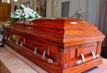 Wooden casket with white flowers in a funeral home